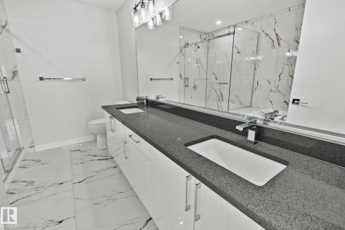 Full bath featuring double vanity, a marble finish shower, and light marble finish flooring - 3524 41 Ave, Beaumont, AB - Indoor Photo Showing Bathroom