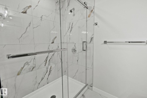 Full bath featuring a marble finish shower and baseboards - 3524 41 Ave, Beaumont, AB - Indoor Photo Showing Bathroom
