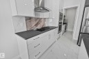 Kitchen featuring extractor fan, white cabinetry, stainless steel appliances, modern cabinets, and light marble finish flooring - 3524 41 Ave, Beaumont, AB  - Indoor Photo Showing Kitchen With Upgraded Kitchen 