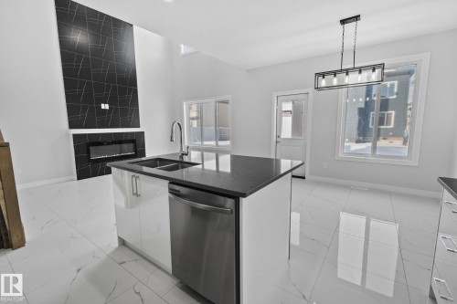 Kitchen featuring white cabinetry, stainless steel dishwasher, plenty of natural light, and a kitchen island with sink - 3524 41 Ave, Beaumont, AB - Indoor Photo Showing Kitchen With Double Sink