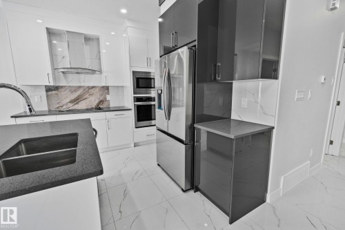 Kitchen with modern cabinets, stainless steel appliances, recessed lighting, dark stone counters, and backsplash - 3524 41 Ave, Beaumont, AB - Indoor Photo Showing Kitchen With Double Sink With Upgraded Kitchen