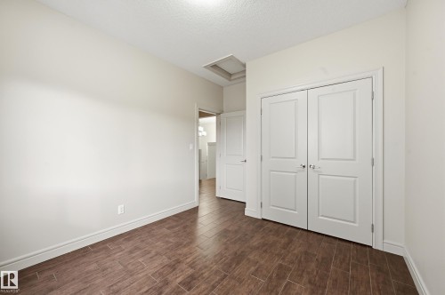 Unfurnished bedroom with wood tiled floors, a closet, and a textured ceiling - 1346 Cunningham Drive W, Edmonton, AB - Indoor Photo Showing Other Room