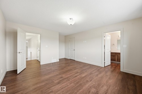 Unfurnished bedroom with dark wood finished floors and connected bathroom - 1346 Cunningham Drive W, Edmonton, AB - Indoor Photo Showing Other Room