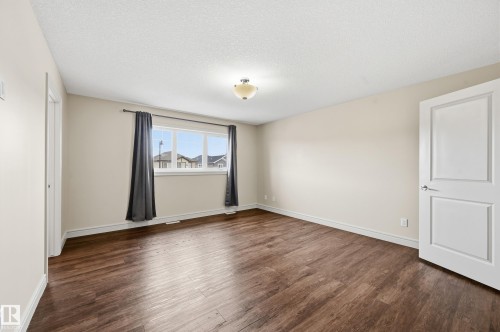 Spare room with dark wood-style flooring and a textured ceiling - 1346 Cunningham Drive W, Edmonton, AB - Indoor Photo Showing Other Room