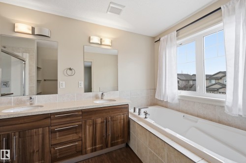 Full bathroom with double vanity, a garden tub, a stall shower, and dark wood-style flooring - 1346 Cunningham Drive W, Edmonton, AB - Indoor Photo Showing Bathroom