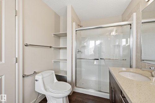 Bathroom featuring vanity, a stall shower, dark wood finished floors, and a textured ceiling - 1346 Cunningham Drive W, Edmonton, AB - Indoor Photo Showing Bathroom