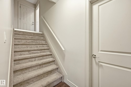 Staircase featuring baseboards and wood finished floors - 1346 Cunningham Drive W, Edmonton, AB - Indoor Photo Showing Other Room