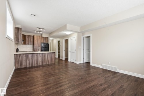 Unfurnished living room featuring dark wood finished floors - 1346 Cunningham Drive W, Edmonton, AB - Indoor Photo Showing Kitchen