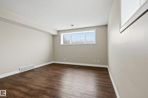 Spare room with dark wood-type flooring and a textured ceiling - 1346 Cunningham Drive W, Edmonton, AB - Indoor Photo Showing Other Room