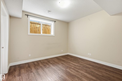 Unfurnished bedroom featuring dark wood-style floors and a textured ceiling - 1346 Cunningham Drive W, Edmonton, AB - Indoor Photo Showing Other Room