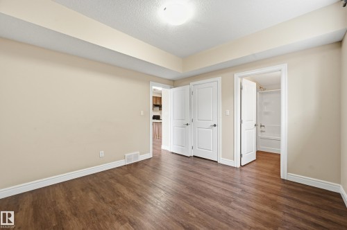 Unfurnished bedroom with dark wood finished floors and a textured ceiling - 1346 Cunningham Drive W, Edmonton, AB - Indoor Photo Showing Other Room