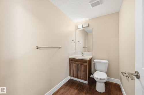 Half bath featuring vanity, dark wood-style floors, and a textured ceiling - 1346 Cunningham Drive W, Edmonton, AB - Indoor Photo Showing Bathroom