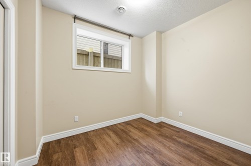 Unfurnished room featuring a textured ceiling and dark wood finished floors - 1346 Cunningham Drive W, Edmonton, AB - Indoor Photo Showing Other Room