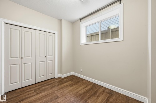 Unfurnished bedroom with a closet, dark wood-type flooring, and a textured ceiling - 1346 Cunningham Drive W, Edmonton, AB - Indoor Photo Showing Other Room