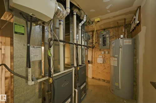 Utilities with water heater, heating unit, and electric panel - 1346 Cunningham Drive W, Edmonton, AB - Indoor Photo Showing Basement