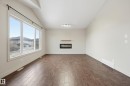 Unfurnished living room featuring a glass covered fireplace, dark wood-style floors, and vaulted ceiling - 1346 Cunningham Drive W, Edmonton, AB  - Indoor With Fireplace 