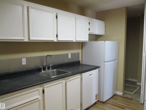 Kitchen featuring dark countertops, white appliances, light wood-type flooring, and white cabinets - 1186 Saddleback Road, Edmonton, AB - Indoor Photo Showing Kitchen