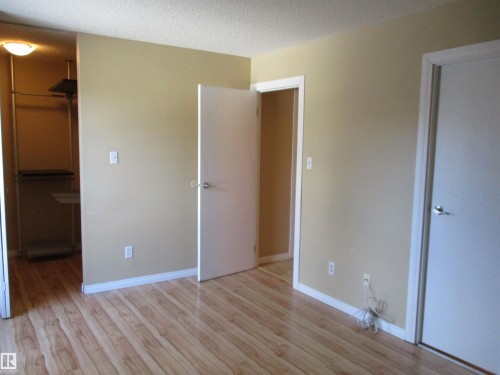 Unfurnished bedroom featuring a walk in closet, light wood-type flooring, and a textured ceiling - 1186 Saddleback Road, Edmonton, AB - Indoor Photo Showing Other Room