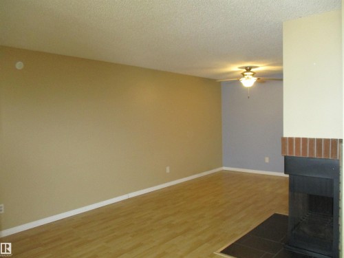 Unfurnished living room featuring light wood-type flooring, ceiling fan, and a textured ceiling - 1186 Saddleback Road, Edmonton, AB - Indoor Photo Showing Other Room