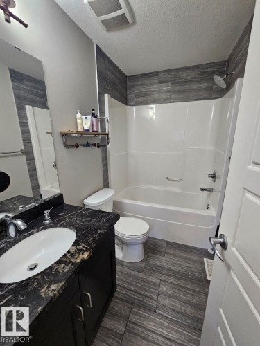 Full bathroom with vanity, bathtub / shower combination, and a textured ceiling - 208 Kirpatrick Way, Leduc, AB - Indoor Photo Showing Bathroom