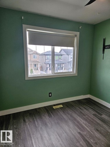 Empty room with dark wood-style floors and baseboards - 208 Kirpatrick Way, Leduc, AB - Indoor Photo Showing Other Room