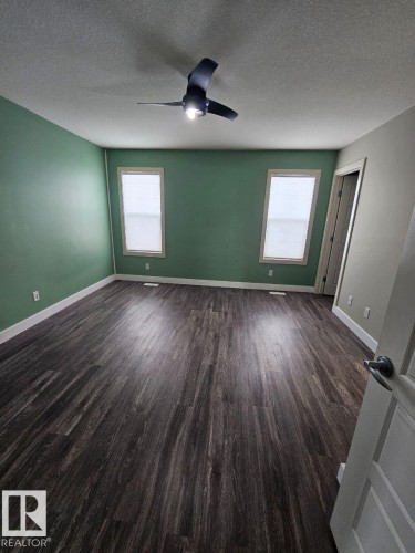Spare room with dark wood-type flooring, a textured ceiling, and a ceiling fan - 208 Kirpatrick Way, Leduc, AB - Indoor Photo Showing Other Room