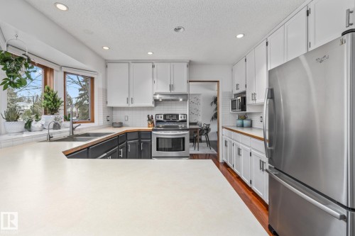 Dual tone kitchen with stainless steel appliances, dual tone cabinets, recessed lighting, dark wood-style flooring, and a textured ceiling - 175 Roy Street, Edmonton, AB - Indoor Photo Showing Kitchen With Upgraded Kitchen