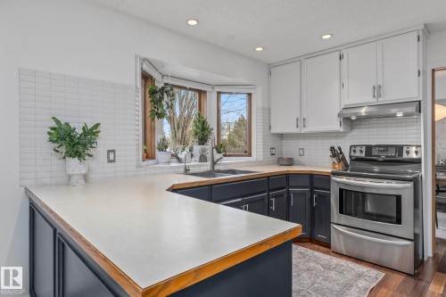 Two tone kitchen with electric stove, two tone cabinetry, a peninsula, dark wood-style flooring, and recessed lighting - 175 Roy Street, Edmonton, AB - Indoor Photo Showing Kitchen