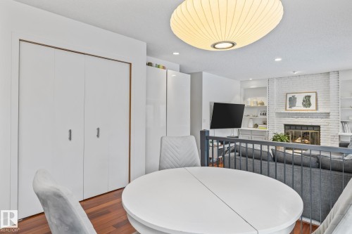 Dining space featuring wood finished floors, recessed lighting, a fireplace, and a textured ceiling - 175 Roy Street, Edmonton, AB - Indoor Photo Showing Dining Room With Fireplace