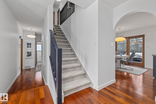 Stairs with arched walkways and hardwood / wood-style flooring - 175 Roy Street, Edmonton, AB - Indoor Photo Showing Other Room