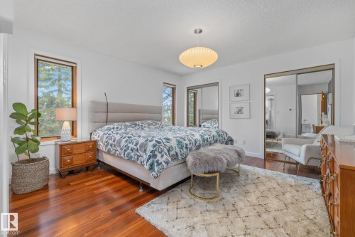 Bedroom featuring dark wood-style floors, two closets, and a textured ceiling - 175 Roy Street, Edmonton, AB - Indoor Photo Showing Bedroom