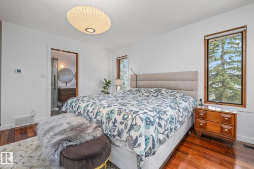 Bedroom featuring dark wood-style flooring and ensuite bathroom - 175 Roy Street, Edmonton, AB - Indoor Photo Showing Bedroom