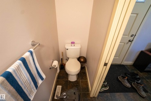 Bathroom featuring toilet and dark tile patterned floors - 5244 1A Avenue Sw, Edmonton, AB - Indoor Photo Showing Bathroom