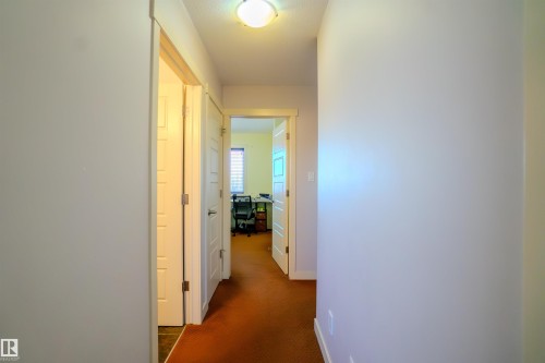 Corridor with dark carpet and baseboards - 5244 1A Avenue Sw, Edmonton, AB - Indoor Photo Showing Other Room
