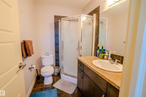 Full bath with a shower stall, vanity, and dark tile patterned flooring - 5244 1A Avenue Sw, Edmonton, AB - Indoor Photo Showing Bathroom