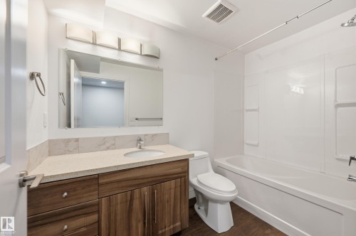 Full bath with vanity, tub / shower combination, and dark wood-style flooring - 1349 Cunningham Drive, Edmonton, AB - Indoor Photo Showing Bathroom