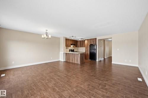 Unfurnished living room featuring dark wood finished floors and hanging lights - 1349 Cunningham Drive, Edmonton, AB - Indoor