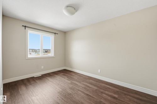 Unfurnished room with baseboards and dark wood-style floors - 1351 Cunningham Drive, Edmonton, AB - Indoor Photo Showing Other Room