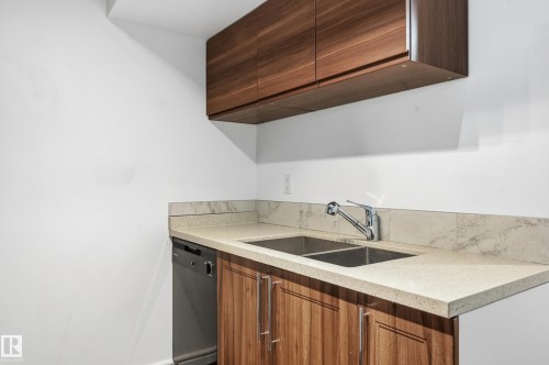 Kitchen with light stone countertops, dishwasher, modern cabinets, and wood finish cabinetry - 1351 Cunningham Drive, Edmonton, AB - Indoor Photo Showing Kitchen With Double Sink