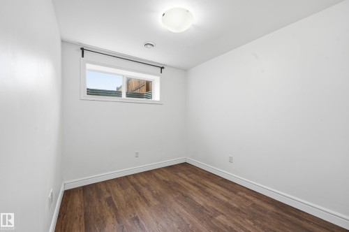 Unfurnished room featuring dark wood-type flooring and baseboards - 1351 Cunningham Drive, Edmonton, AB - Indoor Photo Showing Other Room