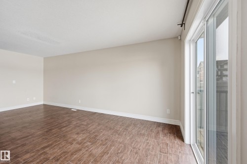 Unfurnished room featuring dark wood-type flooring and baseboards - 1351 Cunningham Drive, Edmonton, AB - Indoor Photo Showing Other Room