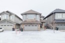 View of front facade with roof with shingles, stone siding, and an attached garage - 1957 Ainslie Link, Edmonton, AB  - Outdoor With Facade 