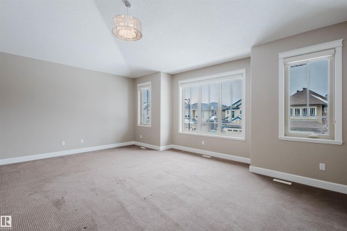 Empty room featuring light colored carpet - 1957 Ainslie Link, Edmonton, AB - Indoor Photo Showing Other Room