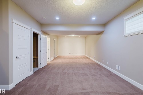 Finished below grade area with recessed lighting, light carpet, and a textured ceiling - 1957 Ainslie Link, Edmonton, AB - Indoor
