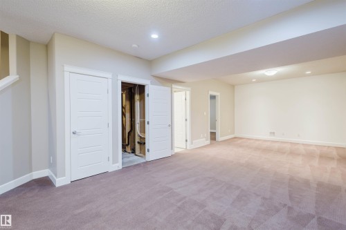 Below grade area featuring light colored carpet, recessed lighting, and a textured ceiling - 1957 Ainslie Link, Edmonton, AB - Indoor Photo Showing Other Room
