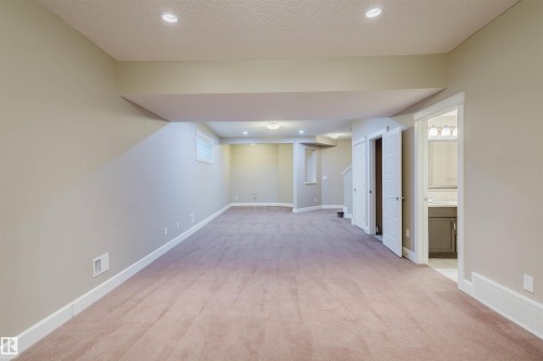 Finished basement featuring light carpet, recessed lighting, and a textured ceiling - 1957 Ainslie Link, Edmonton, AB - Indoor Photo Showing Other Room