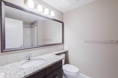 Bathroom featuring vanity, a shower, and a textured ceiling - 1957 Ainslie Link, Edmonton, AB - Indoor Photo Showing Bathroom