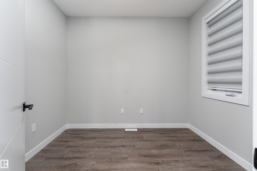 Unfurnished room featuring dark wood-type flooring and baseboards - 5211 Kimball Crescent, Edmonton, AB - Indoor Photo Showing Other Room