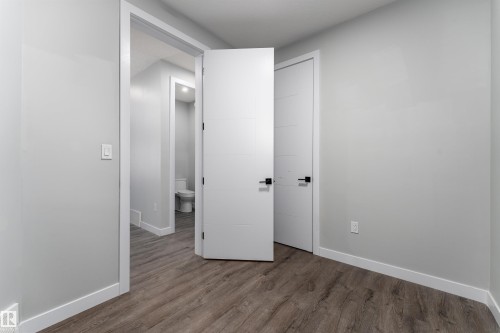 Unfurnished bedroom with dark wood-style flooring and baseboards - 5211 Kimball Crescent, Edmonton, AB - Indoor Photo Showing Other Room
