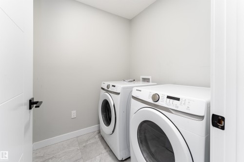 Laundry room featuring washing machine and clothes dryer and baseboards - 5211 Kimball Crescent, Edmonton, AB - Indoor Photo Showing Laundry Room